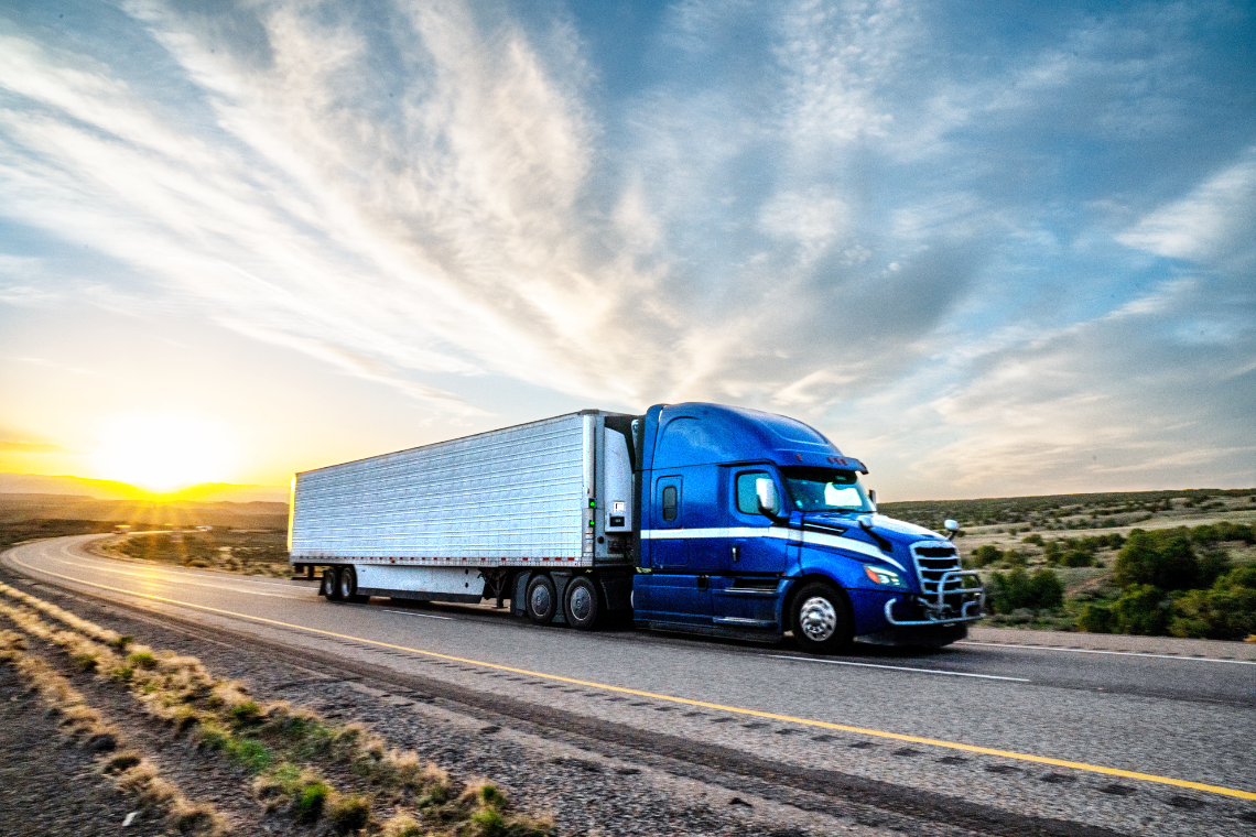 Blue semi truck driving on a highway