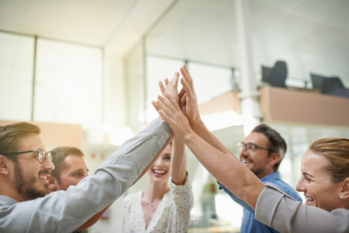 Five office workers giving a high five